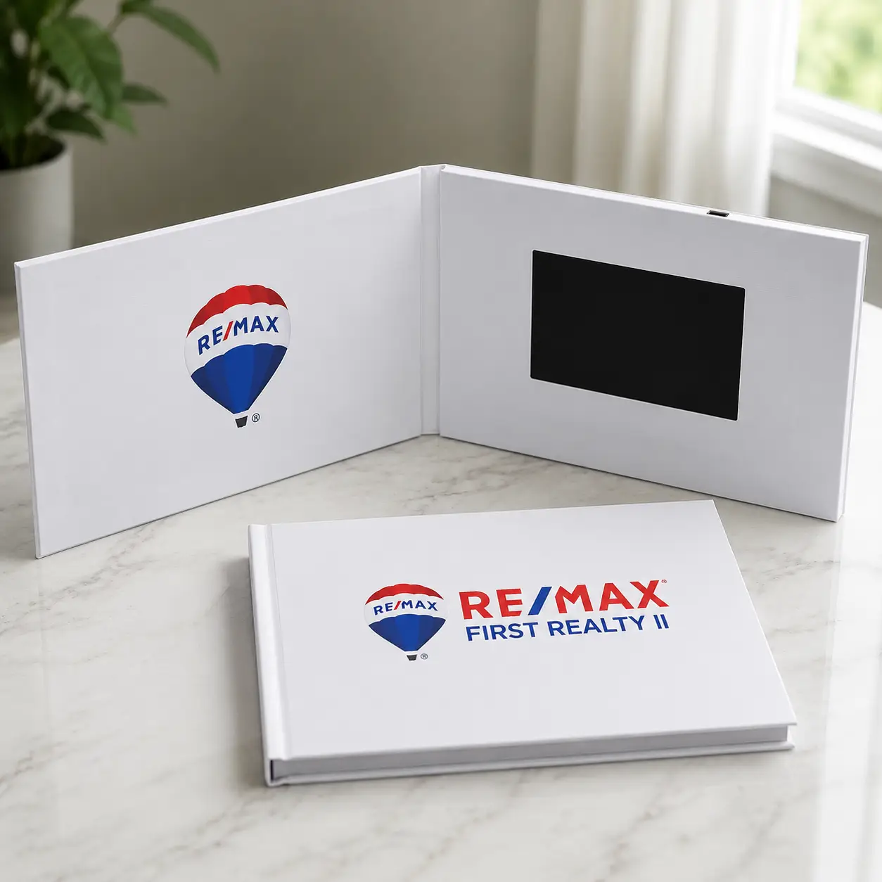 Side by side comparison of a traditional printed listing brochure and a video brochure with embedded screen